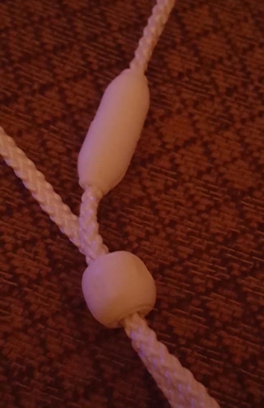 Cord with plastic piece that prevents the cord from being adjusted.