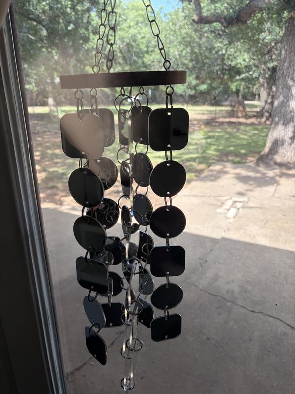 Holding the mirrored wind chime before bringing it outside